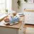 Baby in blue sleepsuit lying on digital scale in nursery, product demo for baby scales.