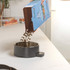 Pouring dry puppy food into a grey dog bowl on a kitchen counter