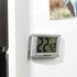 Silver digital kitchen timer attached to fridge door, display showing minutes and seconds