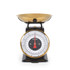 Gold colour mechanical kitchen scale with bowl, shown weighing fresh cherries