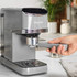 Grey Salter espresso coffee machine on kitchen counter, hand attaching portafilter