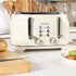 Cream four-slice toaster with chrome accents on kitchen counter