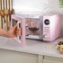 Pink espresso coffee machine making a fresh espresso into a glass cup.