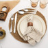 Table setting with cream stoneware plate, woven placemat, linen napkin and silver cutlery
