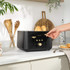 Black and gold four-slice toaster with bagels and bread toasting, angled view