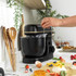 Black and gold stand mixer with whisk, dough hook, and beater attachments.