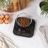 Digital kitchen scale with bowl holding flour, butter, egg and cherries for baking