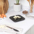 Black digital kitchen scale with chopped butter on weighing surface, shown on countertop