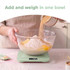 Person washing light green food container under tap in bright kitchen sink