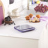 Blue digital kitchen scale on white worktop, shown with muffins and berries.