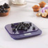 Purple digital kitchen scale with fresh blueberries on weighing surface