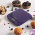 Purple digital kitchen scale with display, surrounded by muffins and berries.