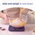 Purple digital kitchen scale with display, surrounded by muffins and berries.