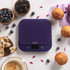 Purple digital kitchen scale on countertop with muffins, berries and coffee