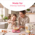 Pink digital kitchen scale on countertop with cakes and baking accessories
