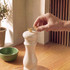 Cream pepper mill with gold top on wooden kitchen worktop