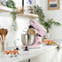 Pink stand mixer with stainless steel bowl, dough hook attached, for home baking