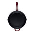 Black cast iron frying pan with red handle, shown from above