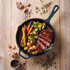 Cast iron pan with roast beef, colourful carrots, potatoes and Brussels sprouts