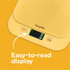 Yellow digital kitchen scale with glass bowl holding flour, butter, and egg; lemons and baking ingredients beside.