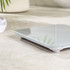 Glass digital bathroom scale with rounded corners on a tiled floor