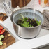 Silver salad spinner with clear lid and black handle, shown open