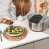 Stainless steel salad spinner with black and clear lid, shown on white background