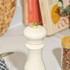 Cream salt grinder with gold top on kitchen worktop