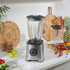 Stainless steel blender base, large glass jug and travel cup, shown together.