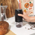 Black electric coffee grinder with clear container, USB charging cable and cleaning brush