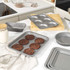 Selection of non-stick grey baking trays and tins with chocolate cookies on a kitchen counter