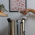 Hand pouring water into stainless steel hot water urn on kitchen counter