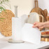 Kitchen roll holder with white paper towel, hand tearing a single sheet