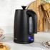 Matte black electric kettle with gold lid being poured