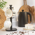 Black electric kettle and cream mugs on kitchen counter with coffee beans