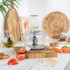 Glass food chopper bowl with chopped vegetables and herbs, top view
