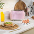 Pink two-slice toaster on kitchen counter with breakfast items, lifestyle setting
