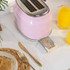 Close-up of pink toaster with crumb tray extended