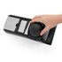 Hand using black and stainless steel mandoline slicer, shown from above, product in use