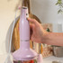 Pink hand blender set with whisk and chopper attachments, shown upright on white background