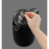 Hand removing limescale filter from black electric kettle