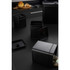 Set of black metal kitchen storage canisters on counter, one open with tea bags visible
