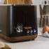 Black two-slice toaster with wood-effect trim and control dial on kitchen counter