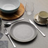 Grey ceramic dinner plate with cutlery, mug and bowl set on tabletop