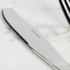 Stainless steel table knife with serrated edge, Salter brand, close up on marble surface