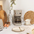 Taupe filter coffee machine on kitchen counter beside cups and toaster