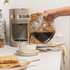 Taupe coffee maker with glass carafe, side view showing water level indicator