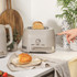 Taupe 2-slice toaster on kitchen counter, toasting bread, with matching kettle