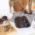 Non-stick muffin tray with four baked chocolate muffins on a kitchen counter