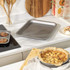 Non-stick baking tray with six cinnamon swirls, shown on kitchen worktop